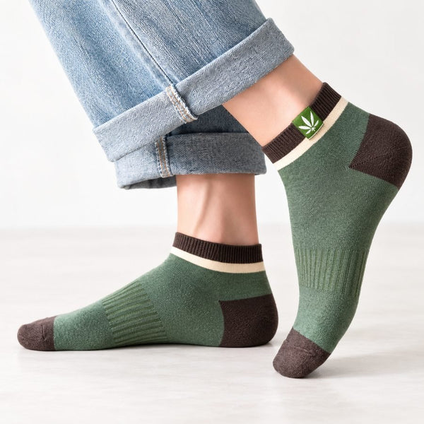 Olive green and brown Cady socks worn on feet with leaf cuff design